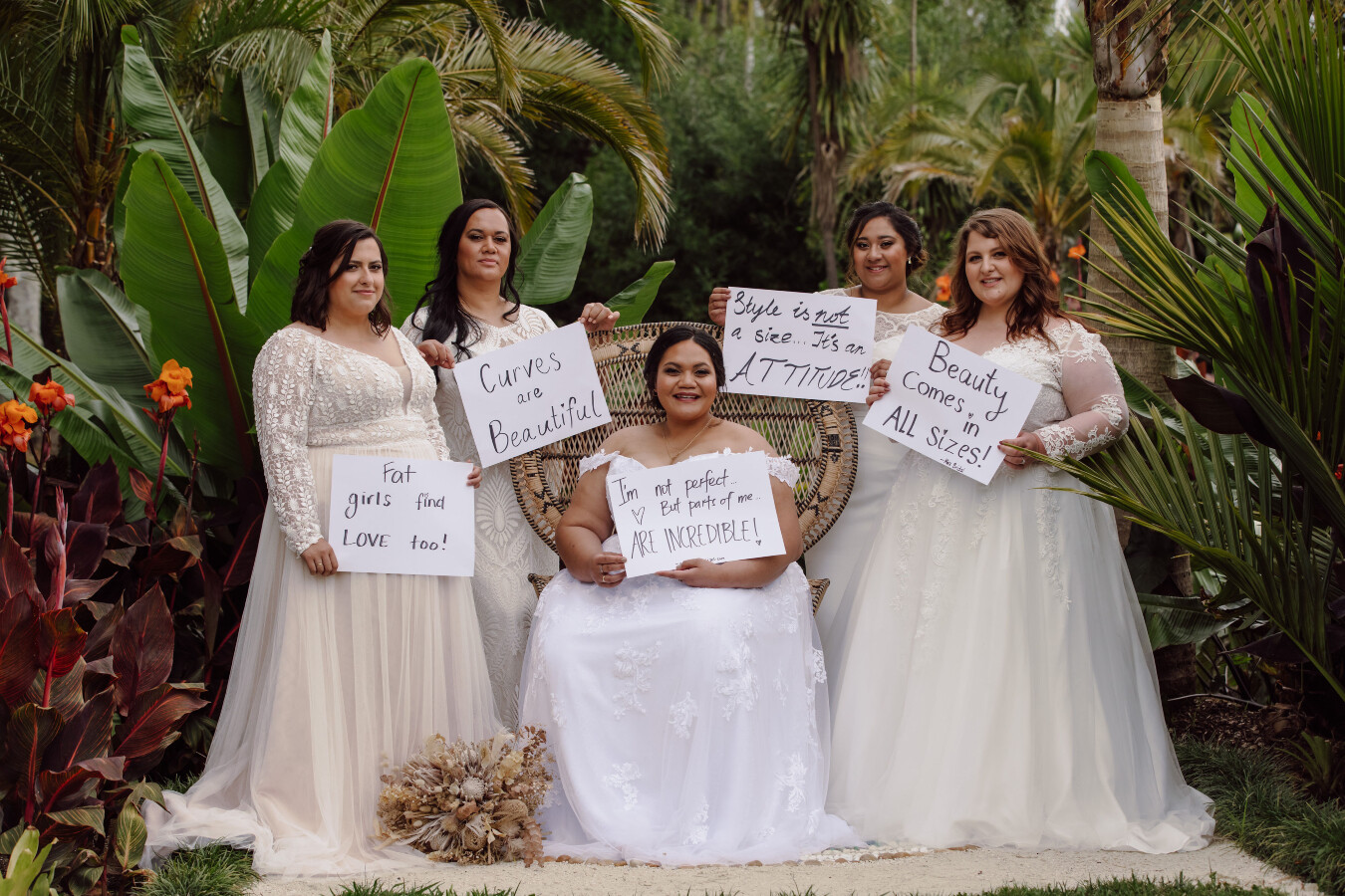 A group of plus size brides holding up signs